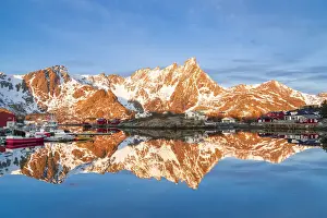 Majestic mountains and fishing village reflected in the cold sea, Ballstad, Vestvagoy, Lofoten Islands, Norway, Scandinavia, Europe