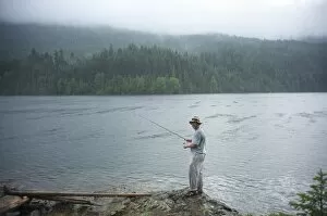 Man, 30 years old, fishes on Ross Lake, North Cascades National Park, Washington