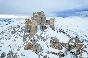 Mature Man Prints: Man admiring the snowy medieval castle of Rocca Calascio after heavy snowfall