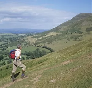 Man ascending Y Grib with Mynydd Bychan in the background, The Black Mountains