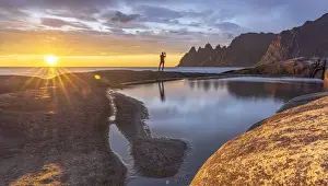 40 45 Years Prints: Man in the backlight sunset photographing the mountain peaks with smartphone, Tungeneset