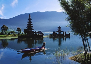 Man in Boat Rowing and Hindu Temples at Lake Bratan, Pura Ulu Danau, Bali Man in Boat Rowing and Hindu Temples at Lake Bratan, Pura Ulu Danau, Bali