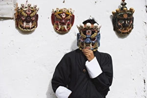 Disguise Prints: Man displaying traditional masks, Thimphu, Bhutan, Asia