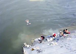 Yoga Prints: Man doing early morning yoga excercises in the water near the dhobi (washing) ghats