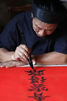 Mature Man Prints: Man doing traditional Chinese writing (calligraphy) in ink using a brush