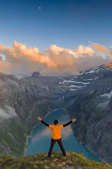 Arms Outstretched Prints: Man with outstretched arms enjoying sunset over lake Limmernsee standing on top of rocks