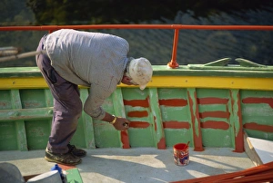 Senior Man Prints: Man painting the inside of a boat on Malta