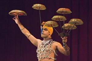 Man performing the Raban Dance and balancing drums in a tourist show at the Kandyan Arts Association Hall, Kandy, Sri