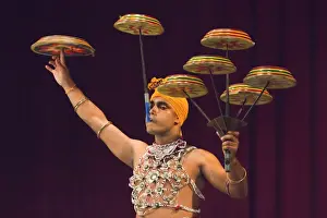 Sri Lanka Prints: Man performing the Raban Dance and balancing drums in a tourist show at the Kandyan Arts Association Hall