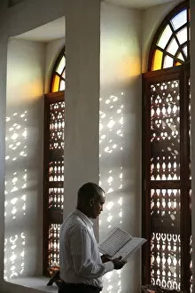 Images Dated 30th July 2007: Man reading Koran in a Doha mosque, Doha, Qatar, Middle East