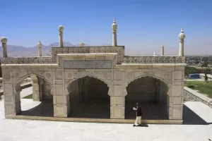 Kabul Prints: Man reading the Koran whilst walking round the white marble Mosque built by Shah Jahan