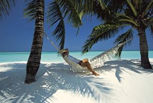 Leisure Activity Prints: Man relaxing on a beachside hammock, Maldives, Indian Ocean, Asia