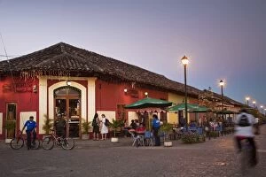 Man rideing bike past restaurant on Calle La Calzada, Granada, Nicaragua, Central America