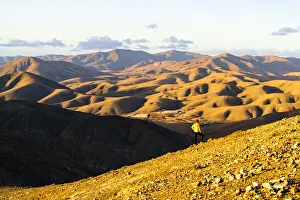 Young Man Prints: Man on ridge admiring sunset over the volcanic landscape near Sicasumbre viewpoint