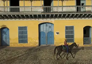 Plaza Mayor Prints: Man riding horse past the Galeria del Arte (Art Gallery), Plaza Mayor, Trinidad