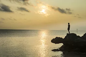 Contemplation Gallery: Man on a rock in backlight on the rocky west coast in Ouvea, Loyalty Islands, New Caledonia