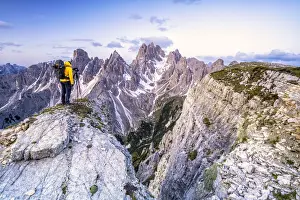 Belluno Prints: Man on top of rocks photographing Cadini di Misurina at sunrise, Dolomites