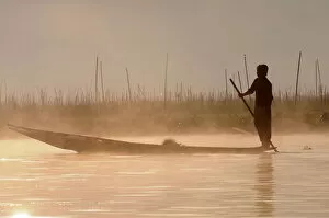Misty Collection: Man rowing his little rowing boat at sunrise on Inle Lake, Shan States, Myanmar, Asia