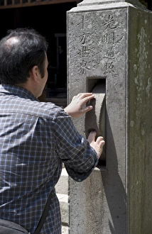Images Dated 1st May 2009: Man spinning a prayer wheel at Zenkoji Temple, Nagano City, Japan, Asia