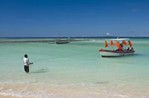 Man standing in the turquoise water of Nosy Iranja near Nosy Be, Madagascar, Africa