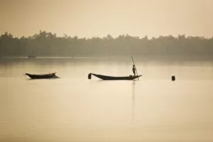 A man stands on a boat in the Sunderbans (Sundarbans) National Park, UNESCO World Heritage Site