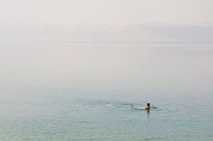 Man swimming in the Dead Sea, Jordan, Middle East