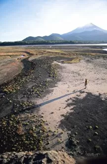 Images Dated 16th June 2010: Man walking on dry lake bed with Llaima Volcano in distance, Conguillio National Park