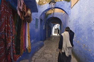 Chefchaouen Prints: Man walking through pastel coloured streets of Chefchaouen