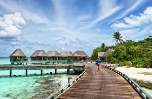 Baa Atoll Prints: Man walking on a wooden jetty, Baa Atoll, Maldives, Indian Ocean, Asia