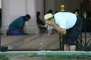 Penang Prints: Man washing before prayers, Kapitan Kling Mosque, Penang, Malaysia, Southeast Asia, Asia