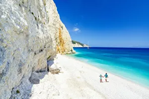 Mid Adults Prints: Man and woman holding hands on the idyllic Fteri Beach