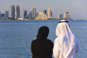 Images Dated 14th December 2007: Man and woman in traditional dress looking across Doha