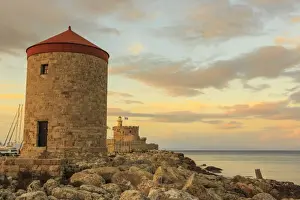 Mandraki Harbour medieval windmill and Fortress at sunset, Rhodes Town, UNESCO World Heritage Site