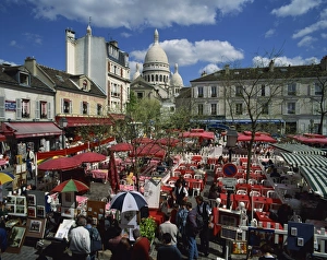 Market stalls and outdoor cafes in the Place du Tertre, with the Sacre Coeur behind
