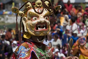 Images Dated 7th April 2009: Masked dancer at religious festival with many visitors, Paro Tsechu, Paro, Bhutan, Asia