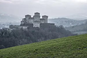 Medieval castle of Torrechiara with square towers on a hill on a foggy day, Torrechiara, Emilia Romagna, Italy, Europe