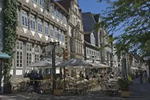 Eating And Drinking Prints: Medieval gables form a background to pavement cafes in Hamelin, Lower Saxony