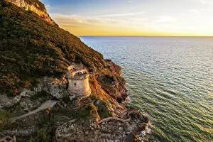 Latina Province Prints: Medieval round tower standing on top of a cliff facing the sea at sunset