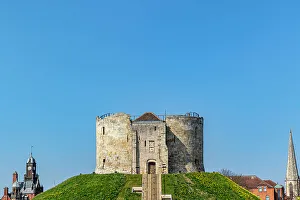York Prints: Medieval stone tower on a grassy hill with clear blue sky