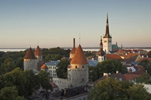 Medieval town walls and spire of St. Olavs church at dusk, Tallinn, Estonia