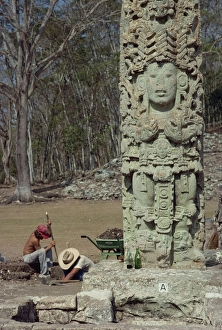 Two men excavating beside the Main Court Stela in