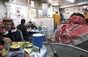 Amman Prints: Men in keffiyeh eating traditional humus in Hashem restaurant