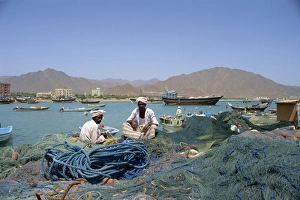 Fishing Net Prints: Men sitting amongst fishing nets at dockside