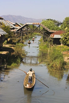 Paddling Prints: Men standing up paddling canoes through floating village, Inle Lake, Shan State