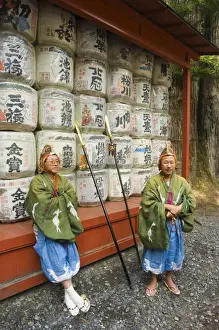 Nikko Prints: Men traditional clothing sitting in front of colourful sake barrels