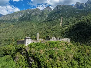 Spot Prints: Mesocco castle stands on a hill surrounded by green forests and mountains in Switzerland