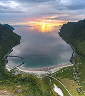 Midnight sun over Ersfjord beach overlooking the Arctic sea, aerial view, Senja