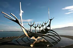 Northern Europe Prints: The midnight sun lights up the giant steel boat sculpture that stands on the waters edge at Reykjavik