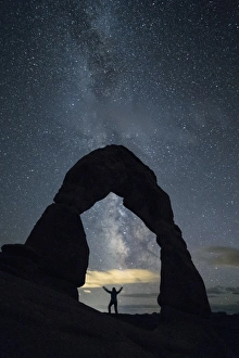 Night Sky Prints: Milky Way and person under Delicate Arch, Arches National Park, Moab, Grand County