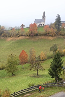 Autumnal Scene Prints: Mist and colourful trees surround the alpine church in the fall